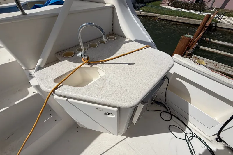 Slide: The Image of 2004 Silverton 43 Motor Yacht sink area with faucet and countertop by the water. - 11