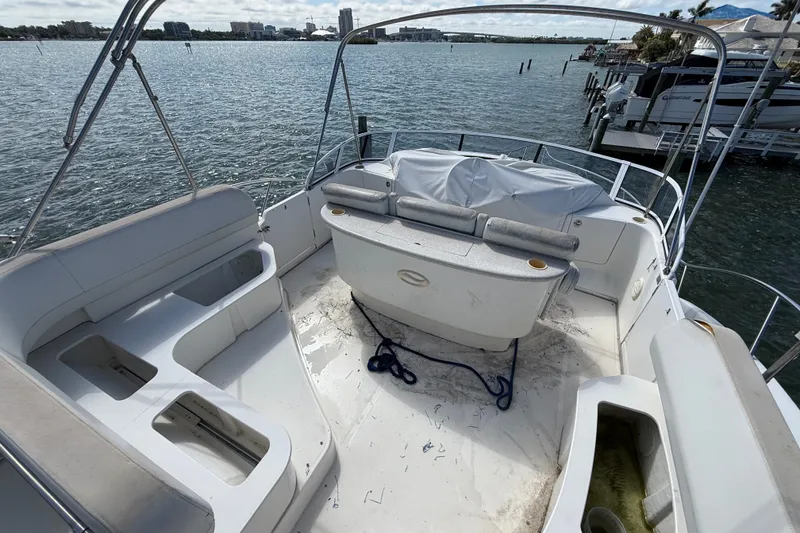 Slide: The Image of 2004 Silverton 43 Motor Yacht deck with seating, overlooking a scenic waterfront. - 16