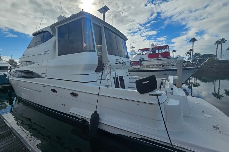 Slide: The Image of 2001 Carver 564 Cockpit Motor Yacht docked at marina under cloudy sky. - 5