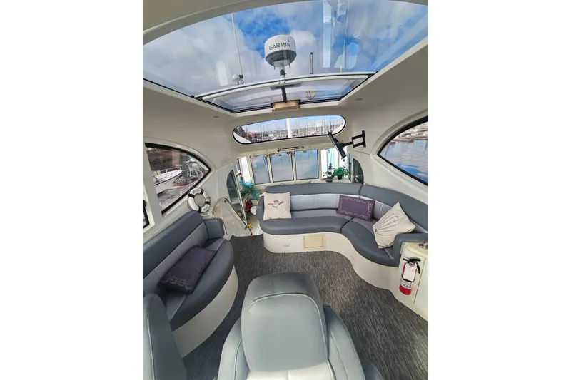 Slide: The Image of Luxurious interior of 2001 Carver 564 Cockpit Motor Yacht with plush seating and panoramic windows. - 49