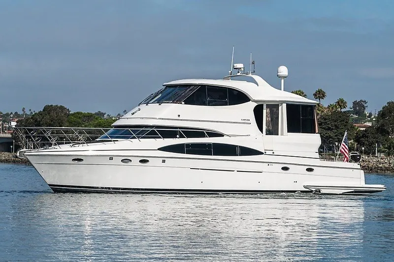 Slide: The Image of 2001 Carver 564 Cockpit Motor Yacht on calm water, side view. - 1