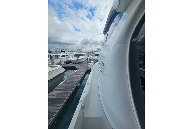 Slide: The Image of 2001 Carver 564 Cockpit Motor Yacht docked at marina under cloudy sky. - 28