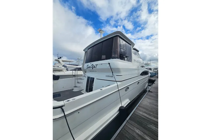 Slide: The Image of 2001 Carver 564 Cockpit Motor Yacht docked under a cloudy sky. - 3