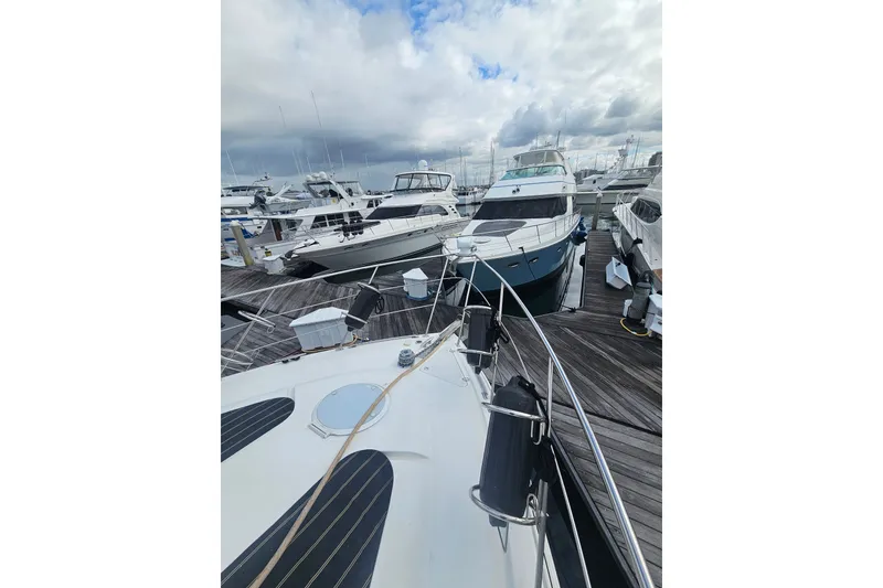 Slide: The Image of 2001 Carver 564 Cockpit Motor Yacht docked among other boats under cloudy skies. - 32