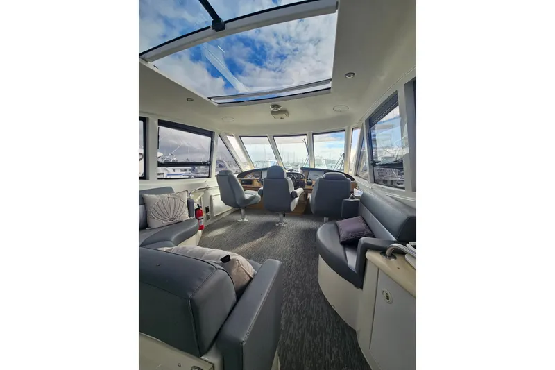 Slide: The Image of Interior of 2001 Carver 564 Cockpit Motor Yacht with spacious seating and panoramic windows. - 42