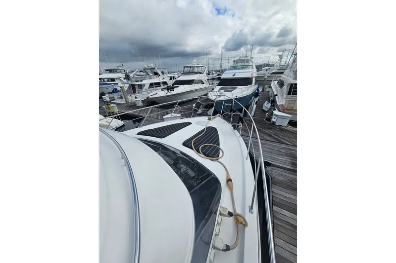Slide: The Image of 2001 Carver 564 Cockpit Motor Yacht docked among other boats under cloudy skies. - 31
