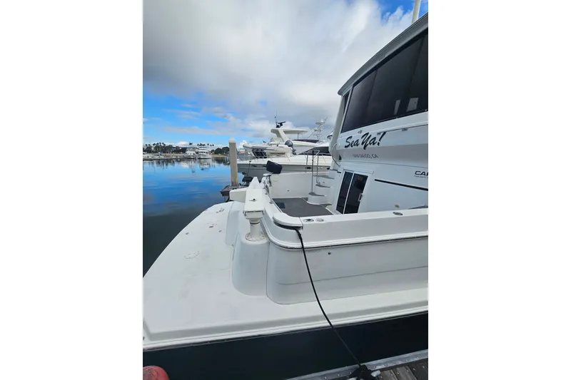 Slide: The Image of 2001 Carver 564 Cockpit Motor Yacht docked in a serene marina setting. - 7