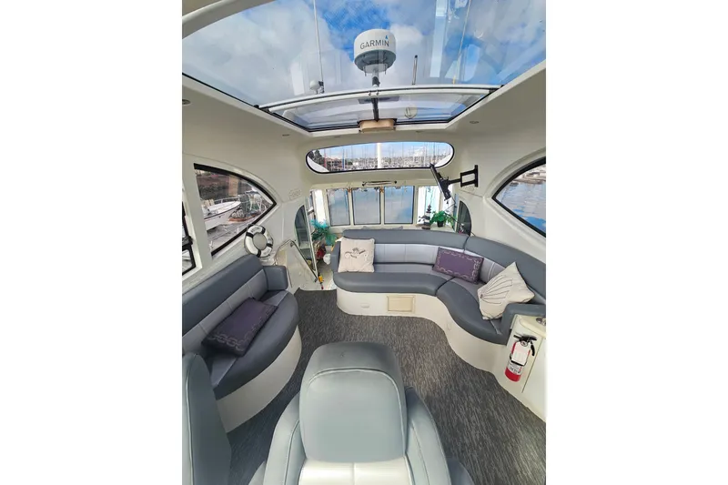 Slide: The Image of Luxurious interior of 2001 Carver 564 Cockpit Motor Yacht with plush seating and panoramic windows. - 50