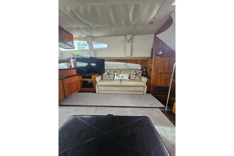 Slide: The Image of Interior of 2001 Carver 564 Cockpit Motor Yacht with sofa, TV, and wooden cabinetry. - 26