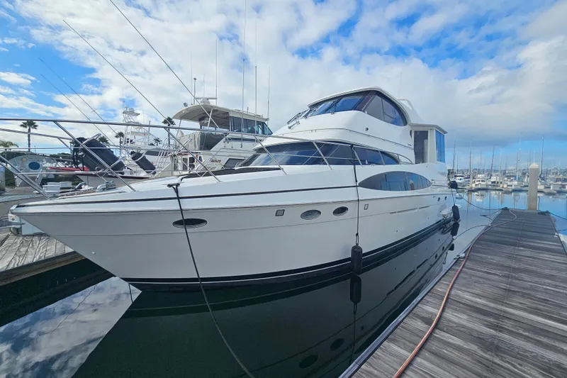 Slide: The Image of 2001 Carver 564 Cockpit Motor Yacht docked at marina under blue sky. - 2