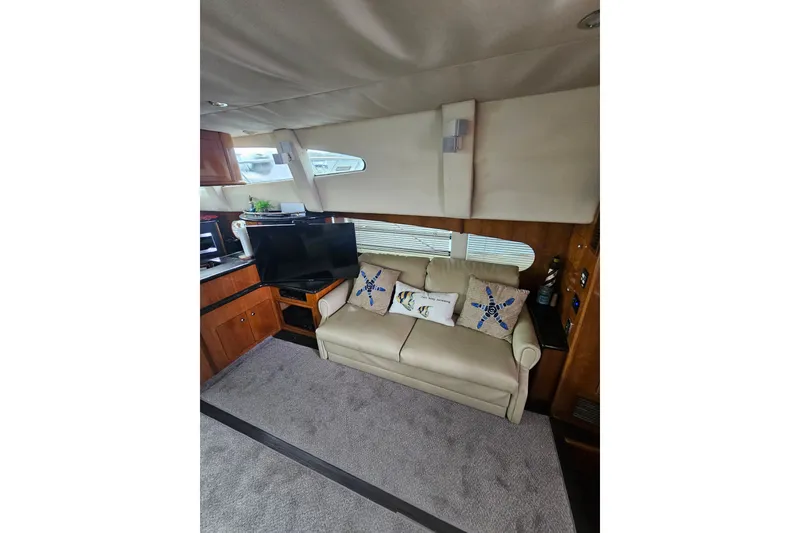 Slide: The Image of Interior of 2001 Carver 564 Cockpit Motor Yacht with sofa, TV, and decorative pillows. - 54