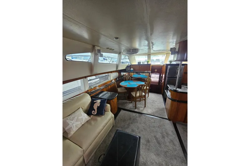 Slide: The Image of Interior of 2001 Carver 564 Cockpit Motor Yacht with dining area and seating. - 53