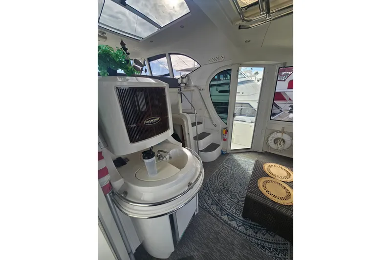 Slide: The Image of Interior of 2001 Carver 564 Cockpit Motor Yacht with seating, decor, and open door. - 40