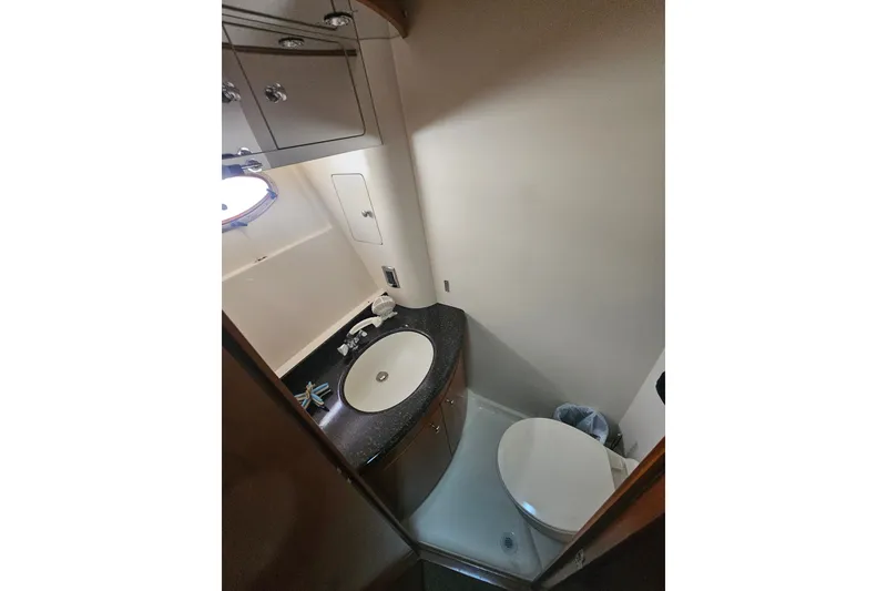 Slide: The Image of Bathroom interior of 2001 Carver 564 Cockpit Motor Yacht, featuring sink and toilet. - 16
