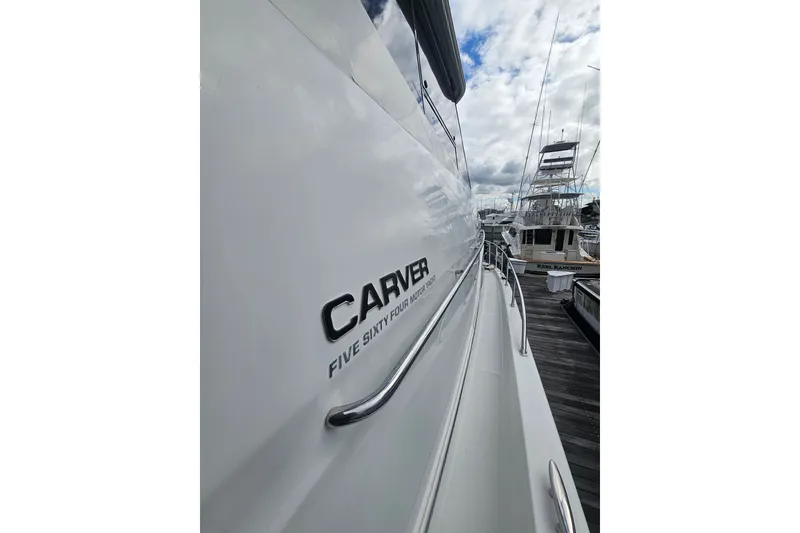 Slide: The Image of 2001 Carver 564 Cockpit Motor Yacht docked, showcasing sleek design and branding. - 30
