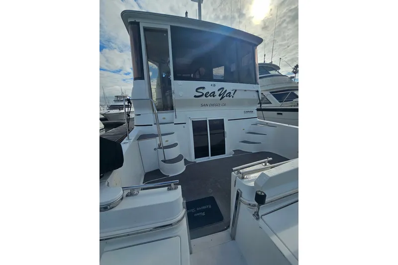 Slide: The Image of 2001 Carver 564 Cockpit Motor Yacht docked, rear view with "Sea Ya!" signage. - 8