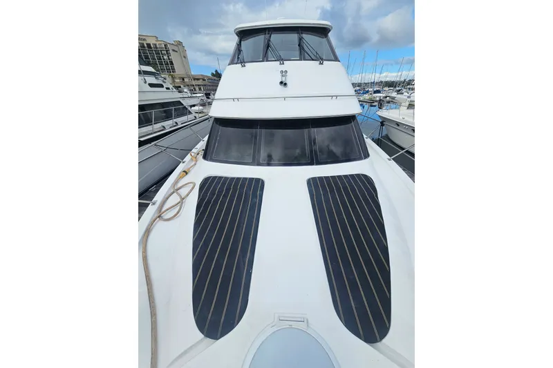 Slide: The Image of 2001 Carver 564 Cockpit Motor Yacht docked at marina, showcasing sleek design and spacious deck. - 33