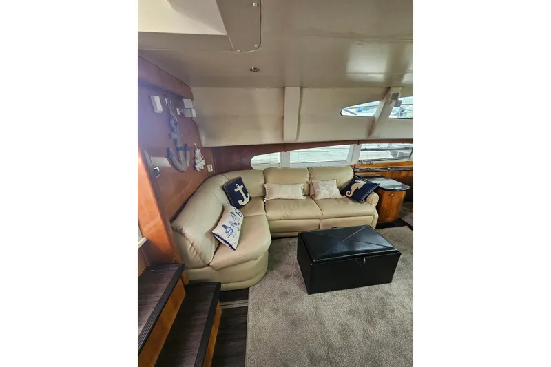 Slide: The Image of Luxurious interior of 2001 Carver 564 Cockpit Motor Yacht with beige sofa and nautical decor. - 52