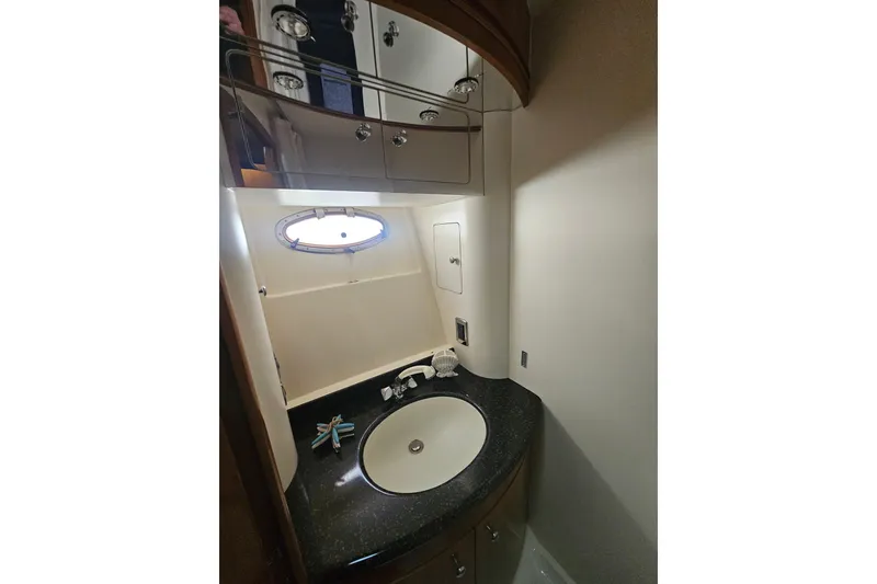 Slide: The Image of Bathroom interior of 2001 Carver 564 Cockpit Motor Yacht with sink and porthole window. - 17