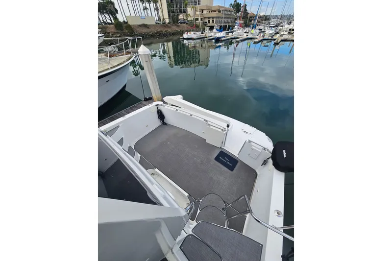 Slide: The Image of 2001 Carver 564 Cockpit Motor Yacht docked in a marina, showcasing spacious deck area. - 38