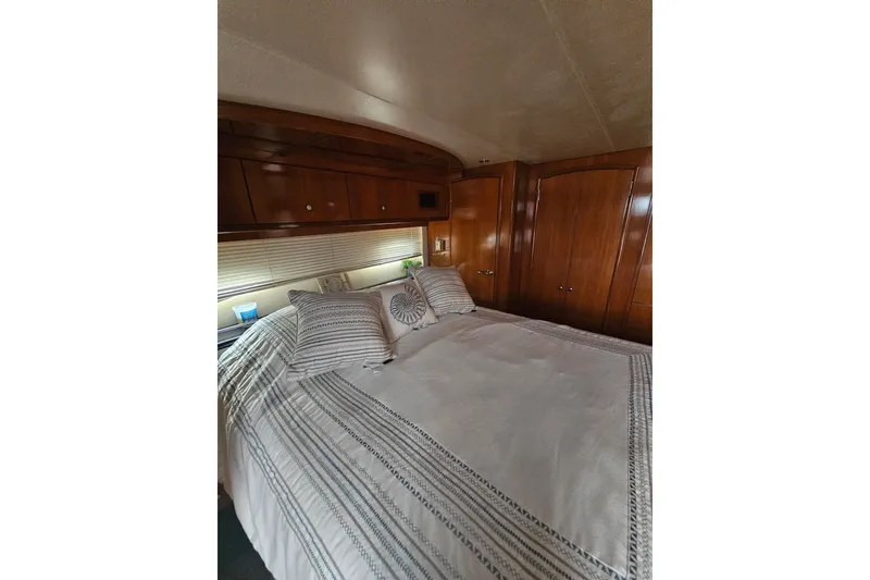 Slide: The Image of Luxurious bedroom interior of 2001 Carver 564 Cockpit Motor Yacht with elegant wood finish. - 24