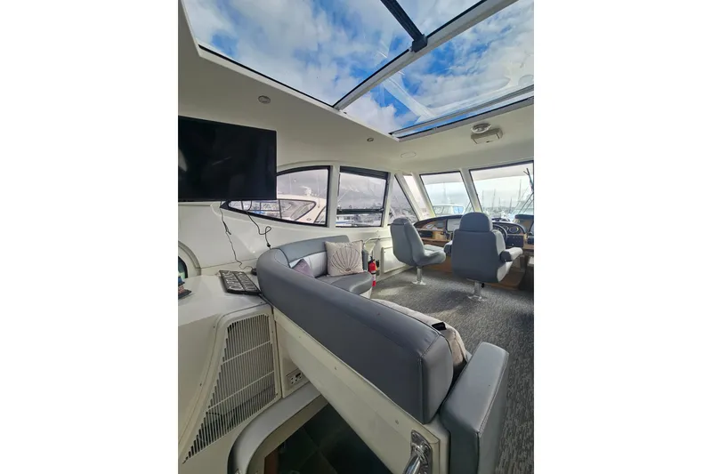Slide: The Image of Interior of 2001 Carver 564 Cockpit Motor Yacht with seating and panoramic windows. - 43