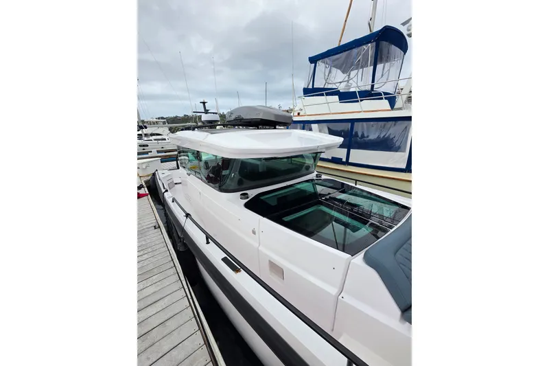 Slide: The Image of 2022 Axopar 37 XC Cross Cabin docked at marina, showcasing sleek design and modern features. - 7