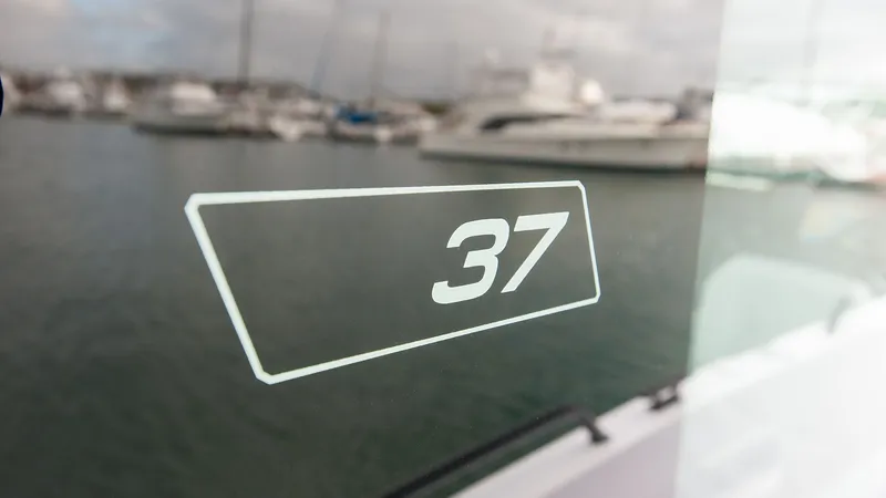 Slide: The Image of Ein Fenster mit der Zahl 37, im Hintergrund Boote im Hafen. - 19