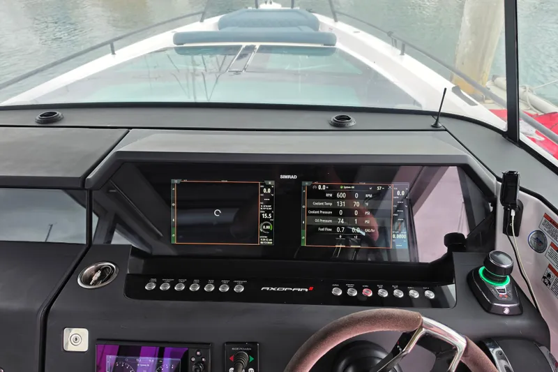 Slide: The Image of 2022 Axopar 37 XC Cross Cabin dashboard with Simrad navigation display and controls. - 22