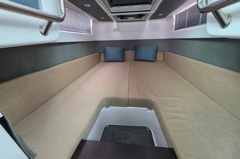 Slide: The Image of Interior cabin of 2022 Axopar 37 XC Cross Cabin with beige seating and blue cushions. - 20