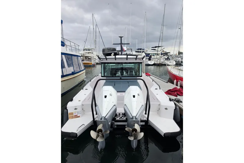 Slide: The Image of 2022 Axopar 37 XC Cross Cabin boat docked at a marina, rear view. - 6