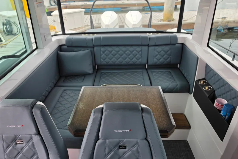 Slide: The Image of Interior of 2022 Axopar 37 XC Cross Cabin with blue seating and wooden table. - 13
