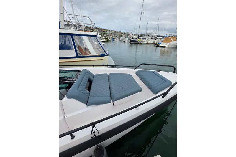 Slide: The Image of 2022 Axopar 37 XC Cross Cabin with cushioned deck, docked in a marina. - 5