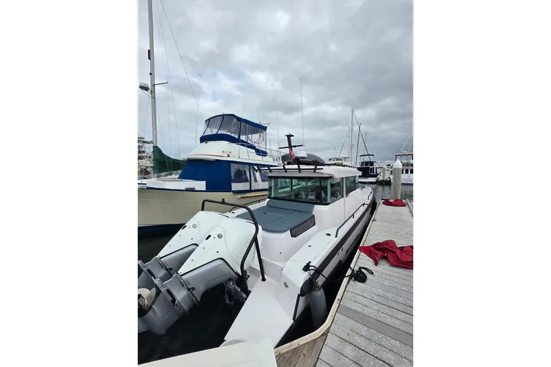 Slide: The Image of 2022 Axopar 37 XC Cross Cabin docked at a marina under cloudy skies. - 4