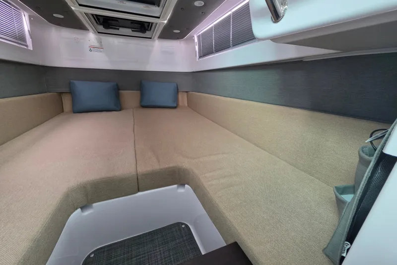 Slide: The Image of Interior cabin of 2022 Axopar 37 XC Cross Cabin with beige seating and blue cushions. - 21