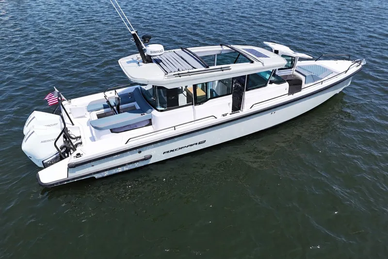 The Image of 2022 Axopar 37 XC Cross Cabin boat on water, featuring sleek design and dual Mercury engines. - 0