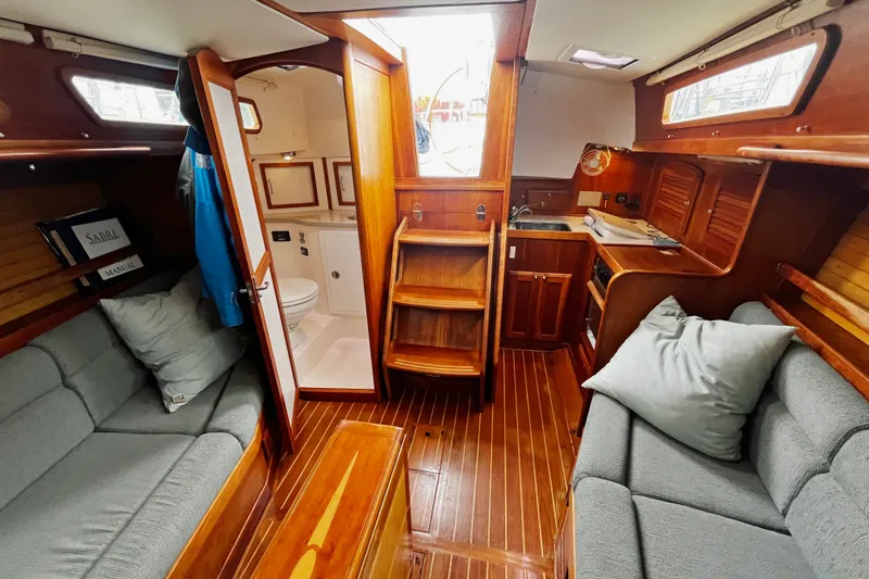 Slide: The Image of 2007 Sabre Spirit yacht interior with wooden finish, cozy seating, and compact kitchen area. - 29