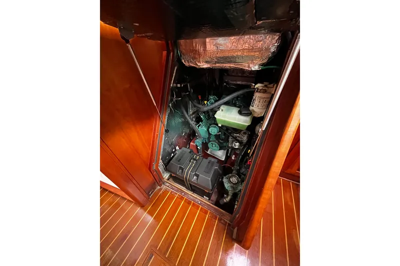 Slide: The Image of Engine compartment of a 2007 Sabre Spirit boat, showcasing mechanical components and wooden flooring. - 36