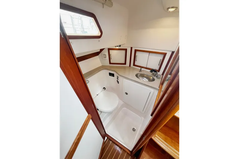 Slide: The Image of Compact bathroom in 2007 Sabre Spirit yacht with sink, toilet, and wooden accents. - 34