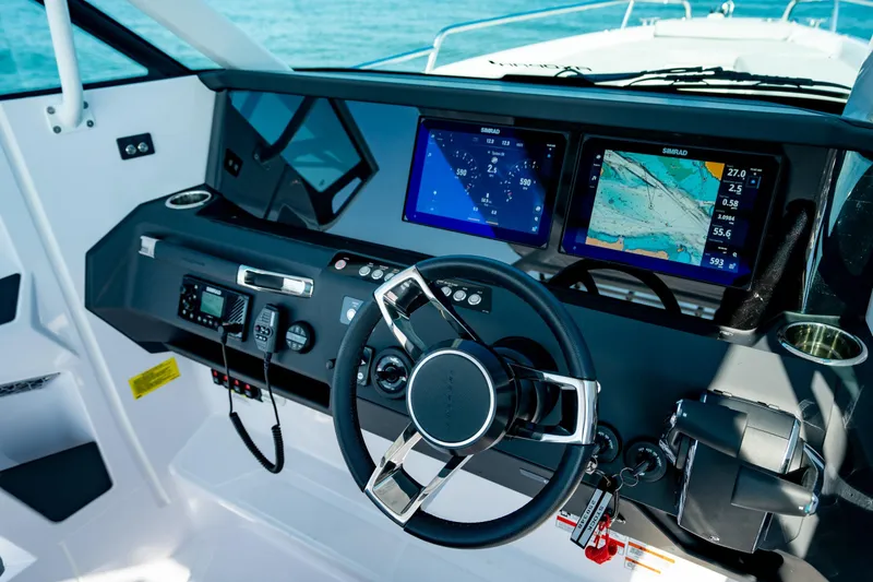 Slide: The Image of 2025 Axopar 29 Sun-Top boat dashboard with advanced navigation displays and controls. - 13