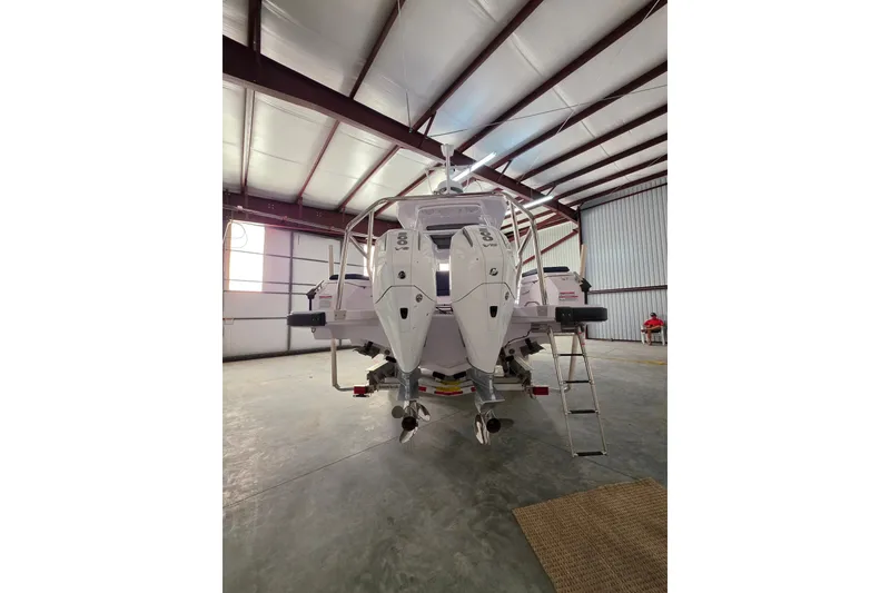 Slide: The Image of 2025 Axopar 29 Sun-Top boat in a spacious indoor storage facility. - 12