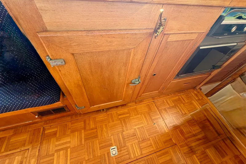 Slide: The Image of Wooden interior of a 1975 Grand Banks 32 Sedan, featuring parquet flooring and cabinetry. - 15