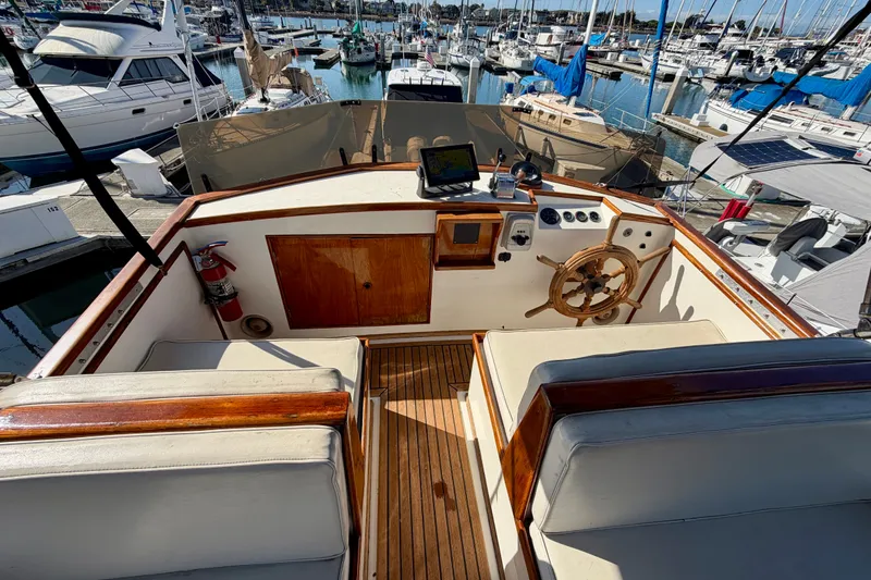 Slide: The Image of 1975 Grand Banks 32 Sedan boat helm with wooden wheel, docked in a marina. - 9