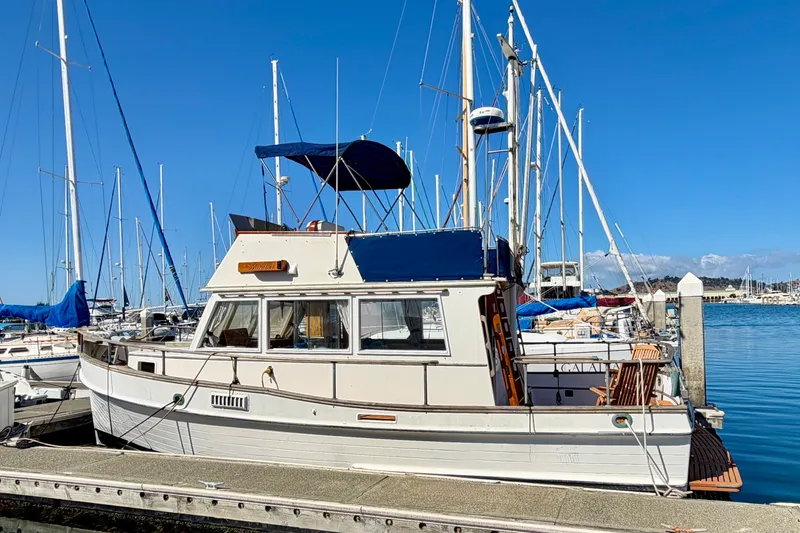 Slide: The Image of 1975 Grand Banks 32 Sedan docked at marina, clear blue sky background. - 1