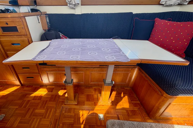 Slide: The Image of 1975 Grand Banks 32 Sedan interior with wooden table and cushioned seating. - 23