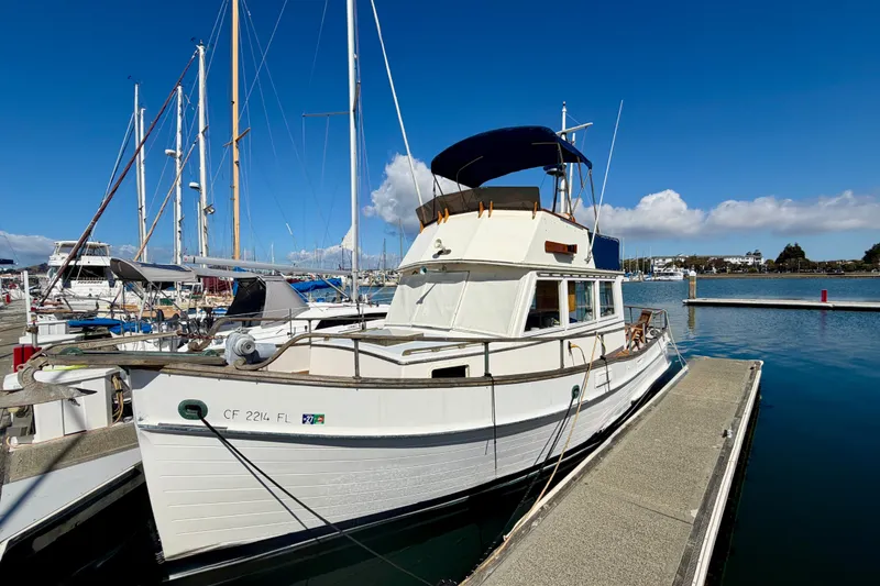 Slide: The Image of 1975 Grand Banks 32 Sedan docked at a marina under a clear blue sky. - 2