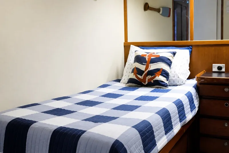 Slide: The Image of Cozy cabin bed in 1981 Bertram 46.6 yacht with nautical-themed decor. - 17