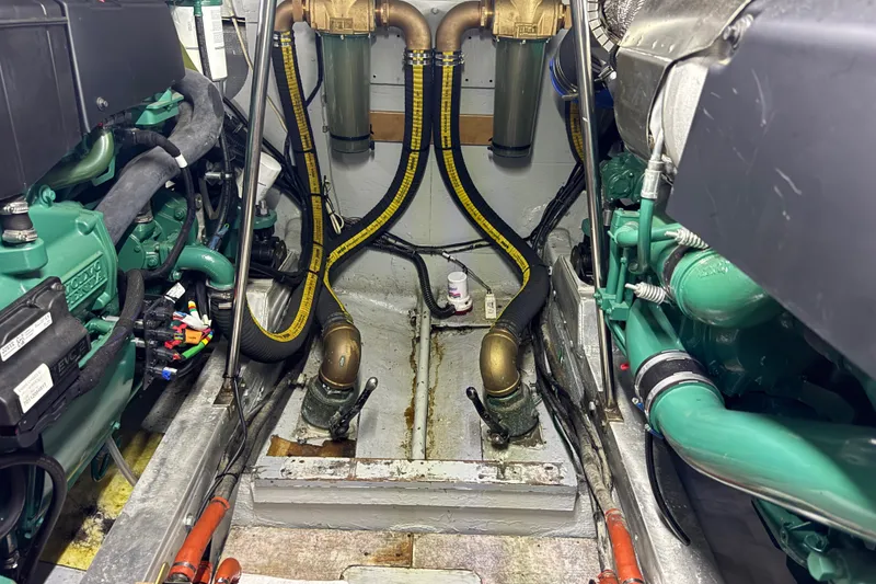 Slide: The Image of Engine room of a 1981 Bertram 46.6 yacht, showcasing mechanical components and hoses. - 36