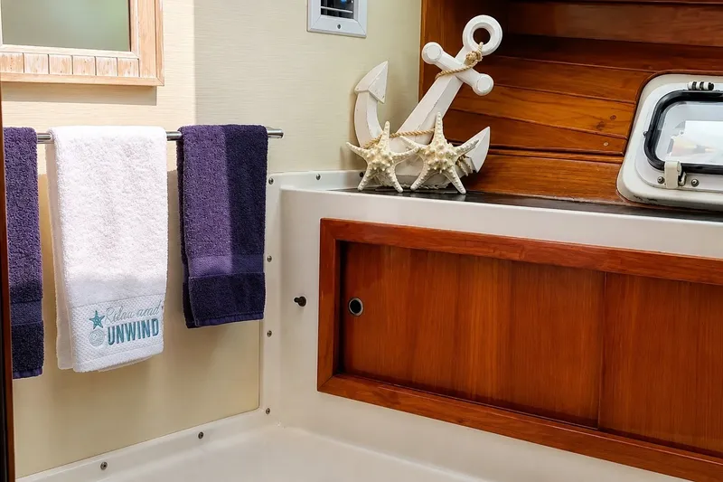 Slide: The Image of Nautical-themed bathroom in 1981 Bertram 46.6 yacht with towels and anchor decor. - 19