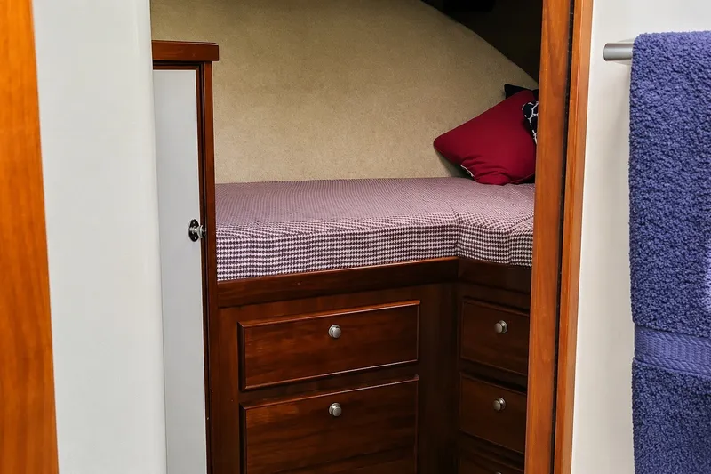 Slide: The Image of Cozy cabin interior of 1981 Bertram 46.6 yacht with wooden drawers and bed. - 21